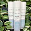 Three bottles of Re/Start Balance Anti Dandruff Micellar Shampoo (250 ml each) stand upright among lush green leaves, emphasizing the refreshing essence and effective anti dandruff formula.