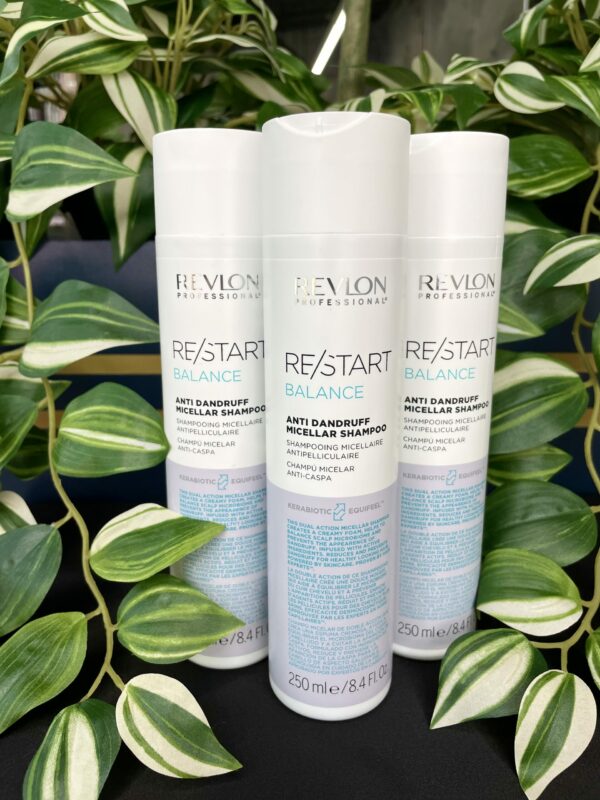 Three bottles of Re/Start Balance Anti Dandruff Micellar Shampoo (250 ml each) stand upright among lush green leaves, emphasizing the refreshing essence and effective anti dandruff formula. Three bottles of Re/Start Balance Anti Dandruff Micellar Shampoo (250 ml each) stand upright among lush green leaves, emphasizing the refreshing essence and effective anti dandruff formula.