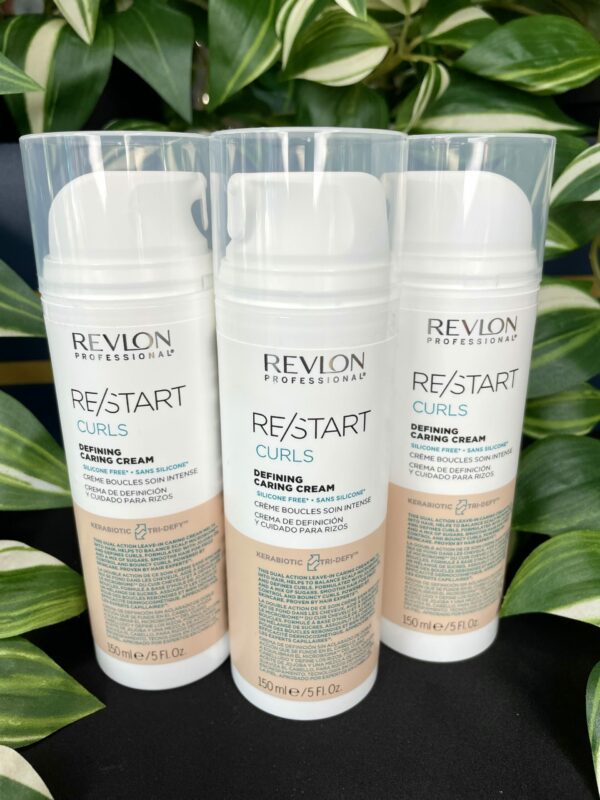 Three bottles of Re/Start Curls Defining Caring Cream (150ml) stand upright amid green leaves, emphasizing the nourishing benefits of this curl-defining cream. Three bottles of Re/Start Curls Defining Caring Cream (150ml) stand upright amid green leaves, emphasizing the nourishing benefits of this curl-defining cream.