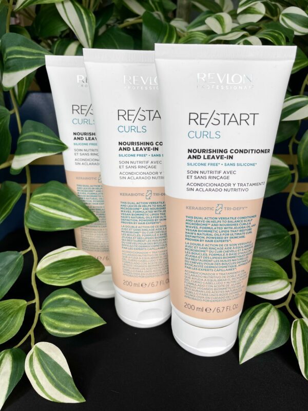 Three 200 ml tubes of Re/Start Curls Nourishing Conditioner and Leave-In stand upright with green plants in the background, emphasizing their nourishing benefits for curls. Three 200 ml tubes of Re/Start Curls Nourishing Conditioner and Leave-In stand upright with green plants in the background, emphasizing their nourishing benefits for curls.