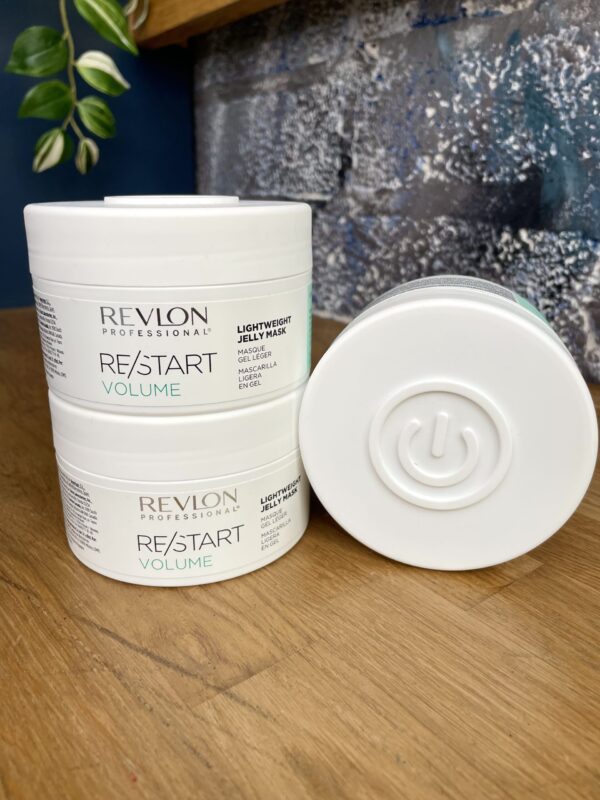 Three containers of Re/Start Volume Lightweight Jelly Mask are stacked on a wooden surface, showcasing its nourishing formula and the distinct power symbol featured on each container’s base. Three containers of Re/Start Volume Lightweight Jelly Mask are stacked on a wooden surface, showcasing its nourishing formula and the distinct power symbol featured on each container’s base.