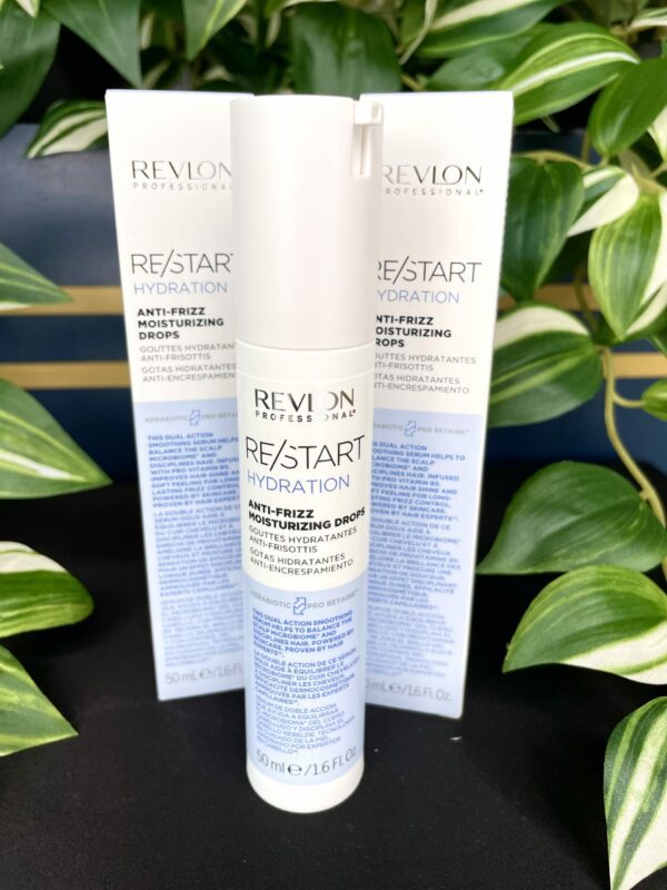 Three bottles of Re/Start Hydration Anti-Frizz Moisturising Drops are displayed before lush green plants, emphasizing their hydrating and anti-frizz benefits for smooth, healthy hair. Three bottles of Re/Start Hydration Anti-Frizz Moisturising Drops are displayed before lush green plants, emphasizing their hydrating and anti-frizz benefits for smooth, healthy hair.