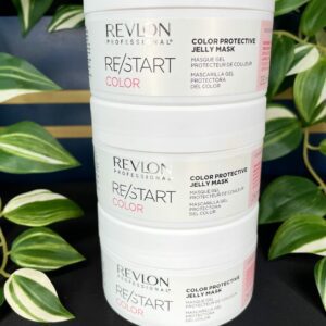 Three stacked containers of the Re/Start Color Protective Jelly Mask are displayed in front of lush green plants, highlighting this nourishing mask’s sleek, color-protective formula.