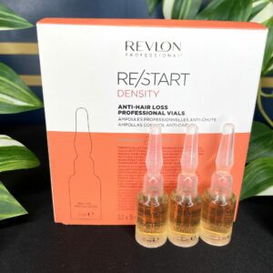 Three Re/Start Density Anti Hair Loss Professional Vials are arranged in front of their product box, with green leaves in the background.