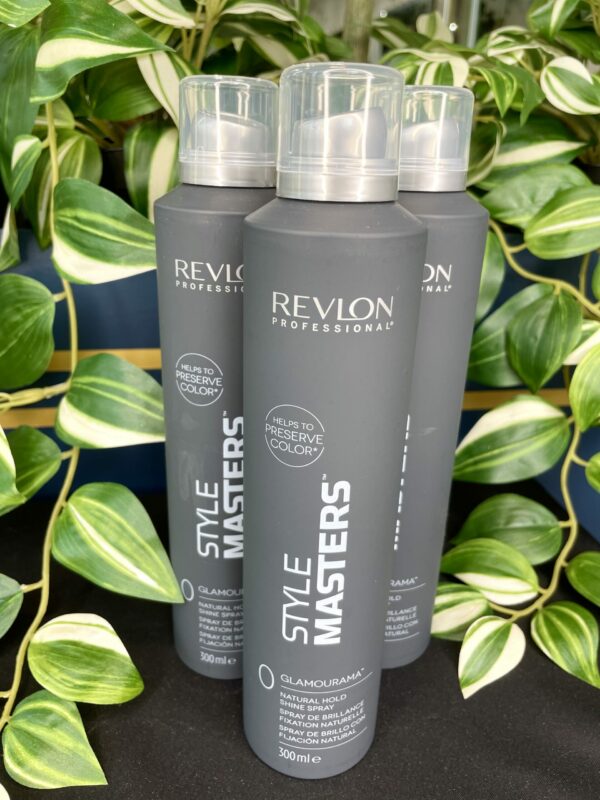 Three bottles of Style Masters Glamourama Shine Spray 300ml stand upright among green and white leafy plants. Three bottles of Style Masters Glamourama Shine Spray 300ml stand upright among green and white leafy plants.