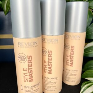 Three bottles of Style Masters Iron Guard Straightening Balm 150ml are displayed upright with green leaves in the background.