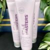 Three tubes of Style Masters Defining Gel 150ml stand upright among lush green plants.