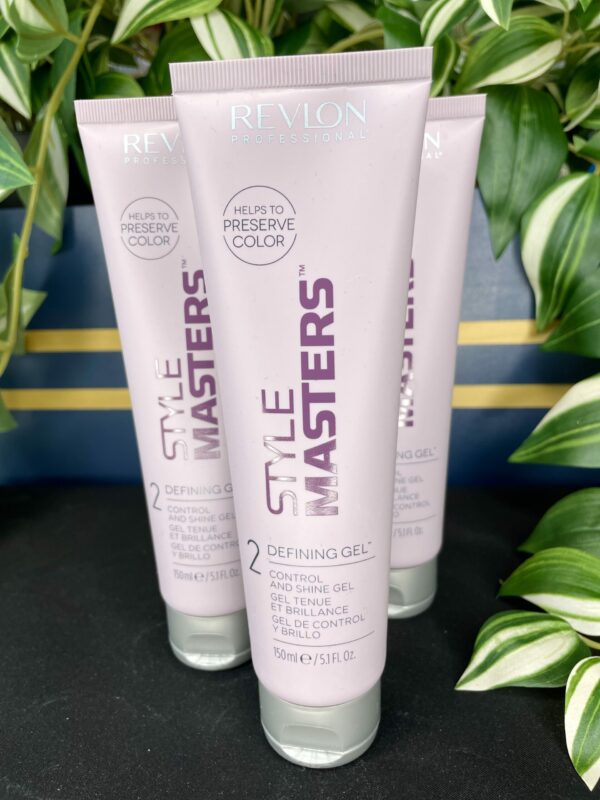 Three tubes of Style Masters Defining Gel 150ml stand upright among lush green plants. Three tubes of Style Masters Defining Gel 150ml stand upright among lush green plants.