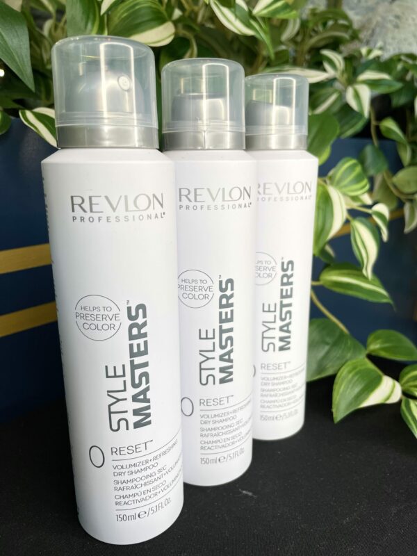 Three bottles of Style Masters Reset Dry Shampoo 150ml are displayed upright with green plants in the background. Three bottles of Style Masters Reset Dry Shampoo 150ml are displayed upright with green plants in the background.