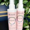 Two bottles of Revlon Magnet Ultimate Daily Fix and Shield Spray 200ml are displayed in front of green variegated leaves.
