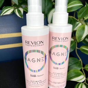Two bottles of Revlon Magnet Ultimate Daily Fix and Shield Spray 200ml are displayed in front of green variegated leaves.